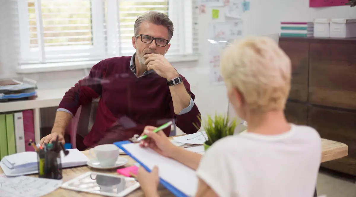 Mitarbeiter im Gespräch mit dem Arbeitgeber über eine geplante Reha-Maßnahme.