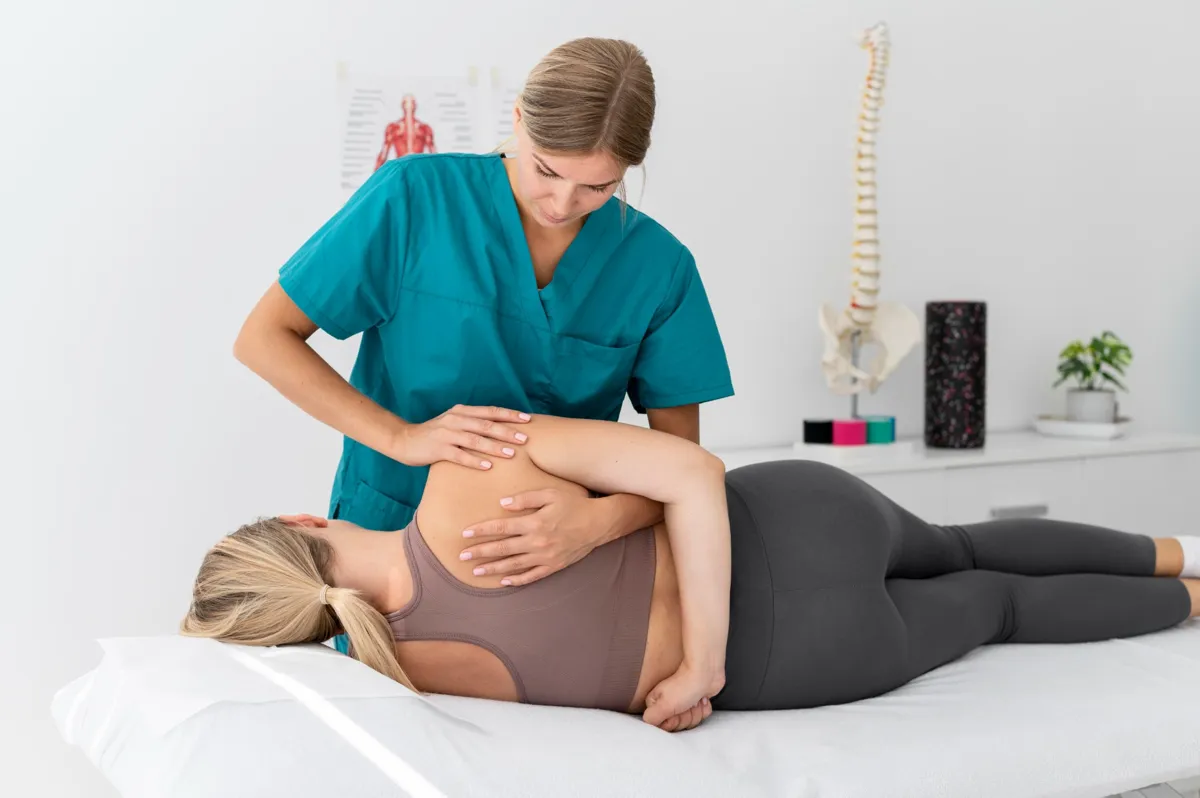 Physiotherapeutin behandelt Patientin mit manueller Technik in Seitenlage zur Entlastung der Wirbelsäule.
