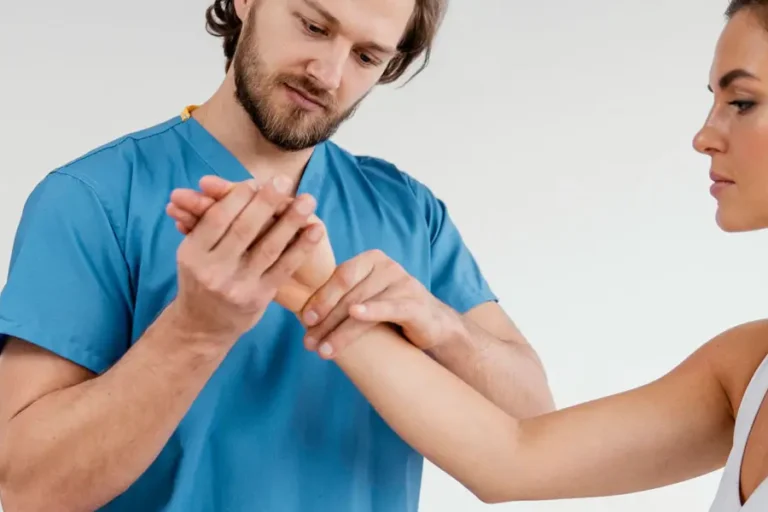 Physiotherapeut untersucht Handgelenk einer Patientin zur Beurteilung der Beweglichkeit und zur Vorbereitung auf gezielte Fingerübungen.