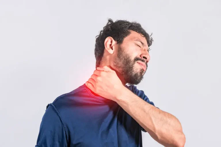 Mann mit Nackenschmerzen greift sich an den Nacken – Symbolbild für Verspannungen und Schmerzen im Hals- und Schulterbereich