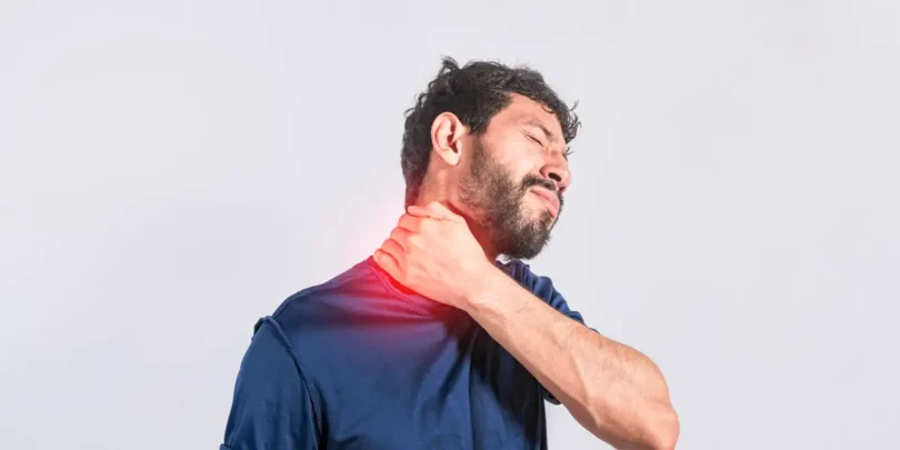 Mann mit Nackenschmerzen greift sich an den Nacken – Symbolbild für Verspannungen und Schmerzen im Hals- und Schulterbereich