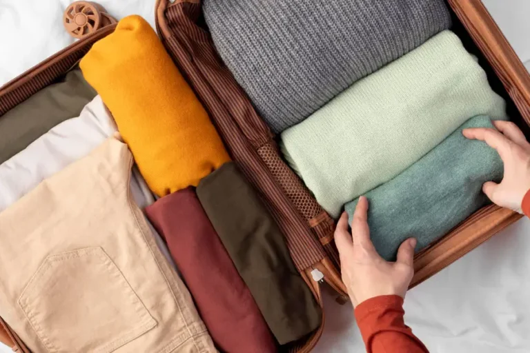 Offener Koffer mit sorgfältig gefalteter Kleidung in verschiedenen Farben – vorbereitet für eine dreiwöchige Reha.