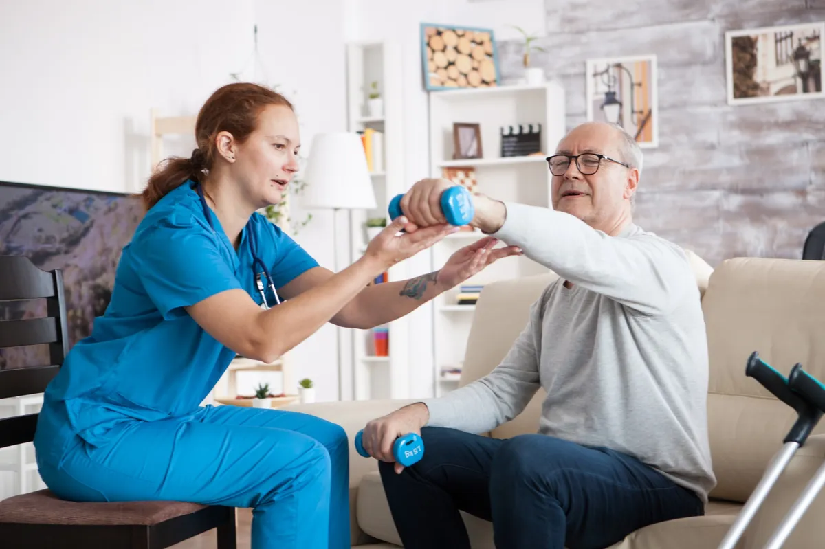 Physiotherapie mit Hanteln in häuslicher Umgebung.